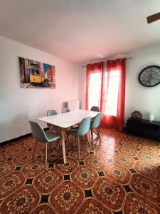 ein Esszimmer mit einem Tisch und Stühlen auf einem Boden in der Unterkunft Les jardins Ducarouge 1 climatisé in Digoin