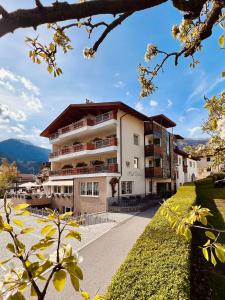 a view of a building with mountains in the background at Hotel Tyrol in Malles Venosta