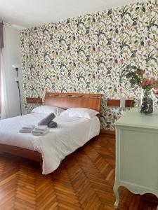 una camera con un letto con una parete floreale di La porta accanto a Padova