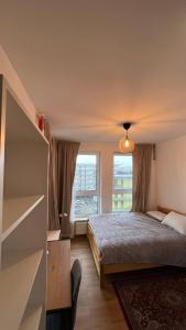 Granata Apartments في لوبلين: غرفة نوم بسرير ونافذة كبيرة