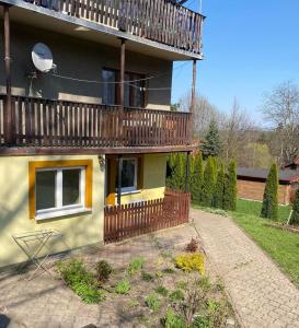 une maison avec une terrasse sur le côté dans l'établissement Pokoje Gościnne Kurza Zagroda, à Jelenia Góra