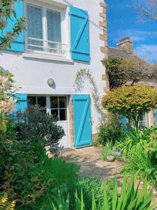 uma casa branca com persianas azuis em KER MAJA : Charmante Maison 1930 * Jardin * 2 vélos * WIFI em Carnac