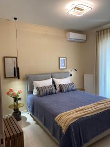 a bedroom with a bed with a blue comforter at Konstantina's Luxury Apartment in Nafplio