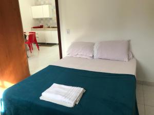 a bed with two towels sitting on top of it at Um lugar no Paraíso ! in Maragogi