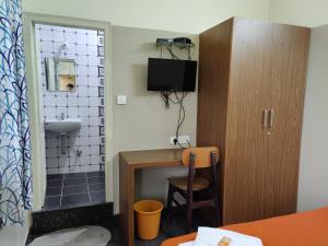 a small bathroom with a sink and a toilet at Rainbow Comforts in Chikmagalūr +21 photos