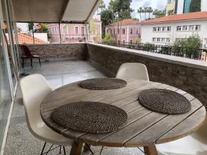 a wooden table and chairs on a balcony at TARİHİ KALEİÇİ MUHTEŞEM DİZAYN HUZURLU KEYİFLİ TERAS KEYİFLİ ÖZEL ev in Antalya