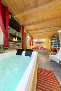 una piscina en una habitación con mesa y sillas en AL RANCH WELLNESS CADORE DOLOMITI APARTMENTS vicino Cortina e Misurina Tre Cime Lavaredo, en Pieve di Cadore