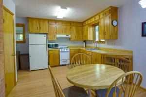 uma cozinha com uma mesa e um frigorífico branco em Vacation Rental Near Shenandoah National Park! em McGaheysville