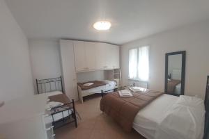 een kleine slaapkamer met een bed en een spiegel bij Appartamenti Enrica in Moneglia