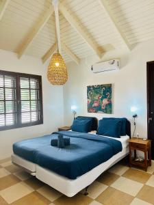 1 dormitorio con 1 cama grande con sábanas azules en Tip! Blue Bay Beachvilla 12 - Blue Bay Resort, en Dorp Sint Michiel