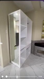 um armário branco num quarto com piso em Michaels Homestay - Farm Villa nr Patar Beach & Bolinao Falls em Bolinao