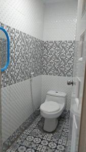a bathroom with a toilet and a tiled floor at Pondok Wisata DEPORIZ 2 in Porisgaga