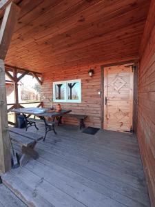 a wooden cabin with a table and a wooden door at Nr3 - W POLU DOBREJ ENERGII 