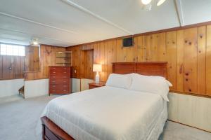 a bedroom with a bed and a wooden wall at Chic Home with Deck, Walk to Lake Erie! 