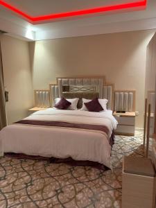 een slaapkamer met een groot bed en een rood plafond bij فندق العزم in Hafr Al Baten