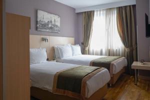 a hotel room with two beds and a window at Hotel Troya in Istanbul