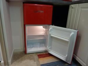 a red refrigerator with its door open in a kitchen at Porta Venezia Studios Lambro 15 in Milan