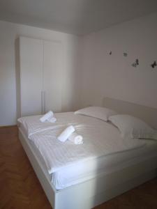 Una cama blanca con dos toallas blancas. en Ivanka Apartments en Vrboska