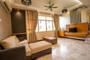 a living room with a couch and a tv at Cozy Gurney Georgetown Private Apartment Penang in George Town