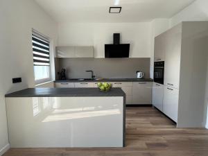 a kitchen with white cabinets and a counter top at Apartment Bencic in Fažana