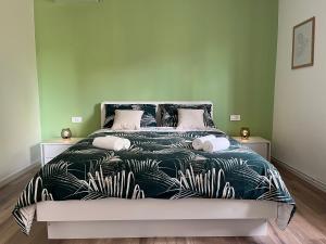 a bed with a black and white comforter with plants at Apartment Bencic in Fažana