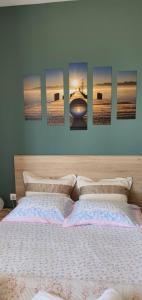 a bedroom with a bed with four paintings on the wall at Terra Kotta in Paralia Vrachou
