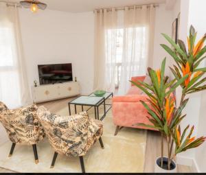 een woonkamer met een bank en een stoel bij Apartamento Jacaranda in La Herradura