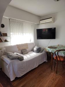 sala de estar con sofá blanco y mesa en Penthouse Almagro Corazon De Buenos Aires en Buenos Aires