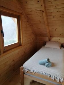 a bed in a log cabin with a window at Vila Bella, Tara, Zaovinsko jezero in Zaovine
