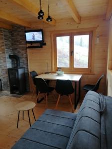 salon z kanapą, stołem i telewizorem w obiekcie Vila Bella, Tara, Zaovinsko jezero w mieście Zaovine