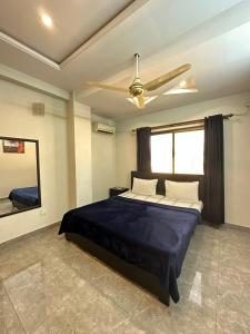 a bedroom with a large bed and a ceiling fan at The Penthouse 2BHK in Islamabad