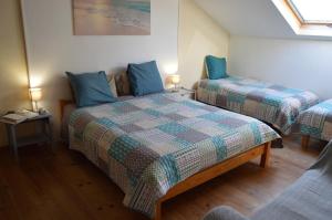 a bedroom with two beds with blue pillows at Le Puy Robin in La Souterraine