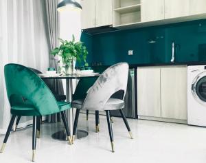 comedor con sillas verdes y mesa en Cali hotel books Da Nang, en Da Nang