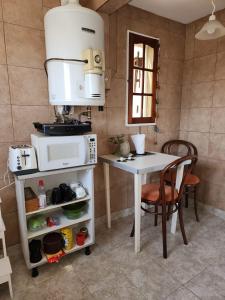 cocina con mesa y microondas en Penthouse Almagro Corazon De Buenos Aires en Buenos Aires