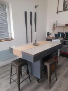 een keuken met een tafel en twee krukken. bij l atelier d alex in La Baule