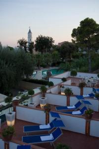 un resort con sedie a sdraio blu e una piscina di Hotel Ristorante Cavaliere a Scario