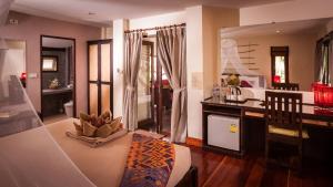a living room with a dining table and a room with at Baan Manali Resort in Thongsala