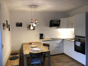 拉特恩斯的住宿－Walli Laterns，一间带木桌的厨房和一间带白色橱柜的厨房