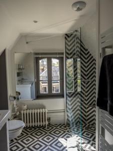 uma casa de banho com piso em xadrez preto e branco em Maison du Moulin em Donzy