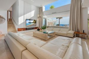 a living room with a white couch and a tv at Blue Sky Mallorca Luxury Villa in Andratx