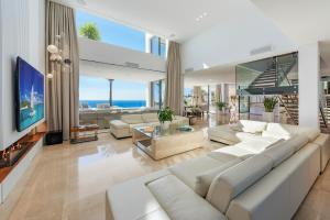 salon z białymi meblami i dużym telewizorem w obiekcie Blue Sky Mallorca Luxury Villa w mieście Andratx