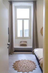 カリアリにあるLa Maison Boheme by Fra Cielo e Mareの窓付きのベッドルーム1室、床に敷物が備わります。
