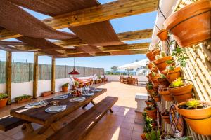 an outdoor patio with wooden tables and potted plants at Stunning terrace with ocean view in Albufeira