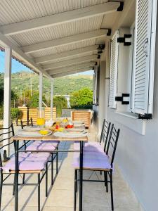 eine Terrasse mit einem Tisch und Stühlen auf dem Balkon in der Unterkunft JAVA GEVA zen living in Kalamaki