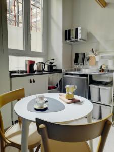 una pequeña cocina con mesa blanca y sillas en Bed & the City - mini loft urbano, en Turín
