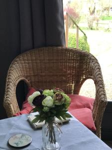 a table with a vase of flowers on a table at au balcon du bonheur in Malandry