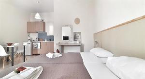 Camera bianca con letto e cucina di Marianna Apartments ad Almirída