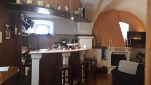 a kitchen with a bar with stools and a fireplace at Hotel Natros in Rocca Pia