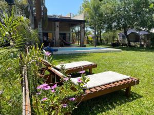 dos bancos sentados en un patio con piscina en Rincón del Potro en Paso de la Patria