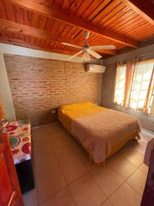 1 dormitorio con cama y pared de ladrillo en Rincón del Potro en Paso de la Patria